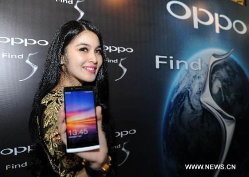 Indonesian actress Sandra Dewi poses with the Find 5 smartphone during OPPO Smartphone launch in Jakarta, Indonesia, April 17, 2013. OPPO officially introduced the establishment of their company in Indonesia and launch of their smartphone lineup Wednesday