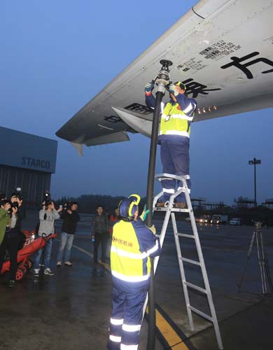 Workers fuel a China Eastern Airlines airplane that uses biofuel for a trial flight early on Wednesday morning in Shanghai. Liu Xin/for China Daily
