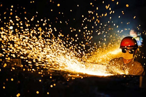 A worker cleans and polishes steel parts at the CITIC Heavy Industries Co Ltd plant in Luoyang, Henan province. China's official PMI has remained above 50 for seven consecutive months, indicating an expansion in factory production. HUANG ZHENGWEI/FOR CHINA DAILY 