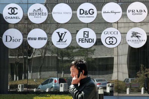 Luxury brand logos in a shop window in Beijing last month. [Photo by Wu Changqing / fop China Daily]