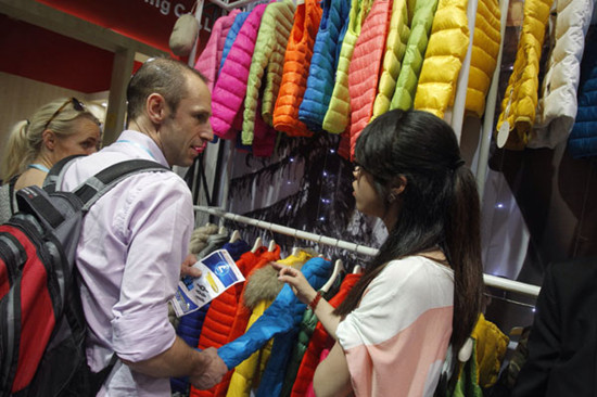 A foreigner asks about the price of a down coat at the 113th Canton Fair in Guangzhou, Guangdong province, on Thursday. [Photo by Chen Wenbi/Yangcheng Evening News]