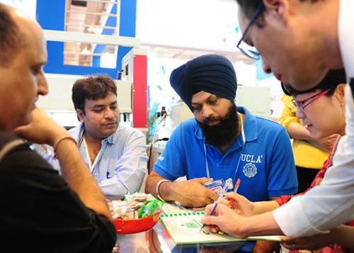 Indian businessmen talk about orders at a footwear exposition in Jinjiang, Fujian province, in April. LIN SHANCHUAN / XINHUA
