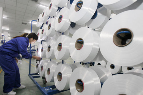 A technician inspects textile materials in Nantong, Jiangsu province. China is competitive in some industries such as textiles, but it needs to take steps to sharpen its competitive edge. XU CONGJUN/FOR CHINA DAILY