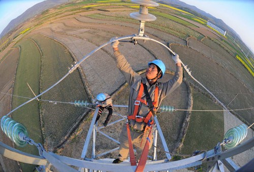 A worker checks and maintains an electric transmission line in Chuzhou, Anhui province. The IMF said Chinas economic growth will pick up moderately in the second half of the year, and the annual GDP growth will be around 7.75 percent. provided to CHINA DAILY
