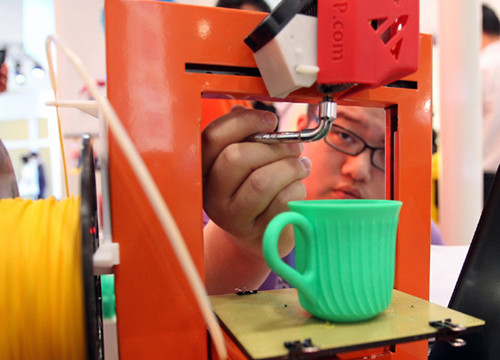 A 3-D printer produces a cup at the China Beijing International Fair for Trade in Services on Wednesday. China's 3-D printing industry generated revenues worth around 1 billion yuan ($163 million) in 2012, according to the Asian Manufacturing Association. [Photo/China Daily]
