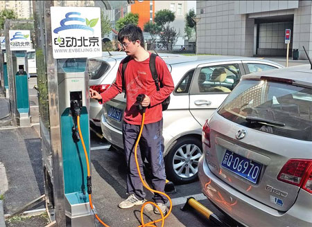 A customer prepares to recharge an electric vehicle at Tsinghua University Science Park in Beijing, where 15 electric cars are available for rent. China encourages the use of green vehicles by offering subsidies and simple license procedures for electric-car buyers. Deng Jia/for China Daily