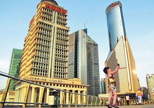 A child takes a self-portrait near skyscrapers in Shanghai's Lujiazui area. Provided to China Daily 