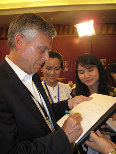 Jon Huntsman writes a message for the media in Chengdu, Sichuan province showing his appreciation for those who organize the Fortune Global Forum on Friday. [Photo by Huang Zhiling/chinadaily.com.cn]