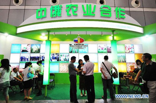 People visit an exhibition area themed on China-Russia agricultural cooperation at the 24th China Harbin International Economic and Trade Fair in Harbin, capital of northeast China's Heilongjiang Province, June 15, 2013. More than 5,000 Russian exhibitors from 74 states and regions of Russia took part in the fair, which opened on Saturday. (Xinhua/Wang Jianwei)