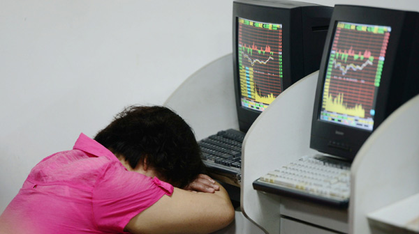 An investor takes a rest at a stock brokerage office in Qingdao, Shandong province, on Wednesday. The Shanghai Composite Index closed at 2,143.45 points after hitting 2,115.79 at one point - its lowest level this year. [Photo/China Daily]