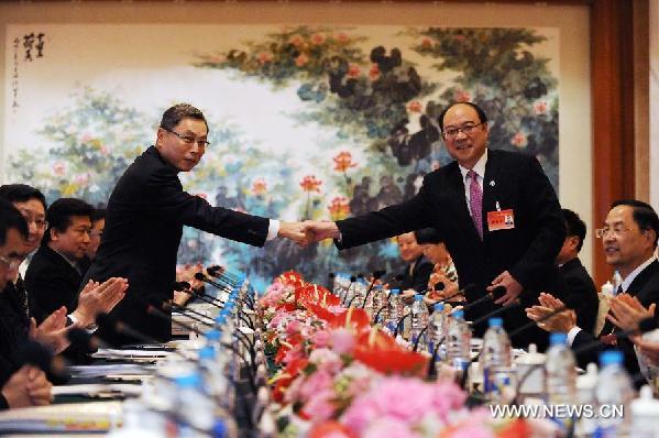 Chinese mainland's Association for Relations Across the Taiwan Straits (ARATS) Executive Vice President Zheng Lizhong (R) and Taiwan-based Straits Exchange Foundation (SEF) Vice Chairman Kao Koong-lian shake hands before a consultation in Shanghai, east China, June 20, 2013. Zheng and Kao co-chaired the preliminary consultation of the ninth round of talks between chief negotiators from the Chinese mainland and Taiwan in Shanghai Thursday afternoon. (Xinhua/Chen Yehua) 