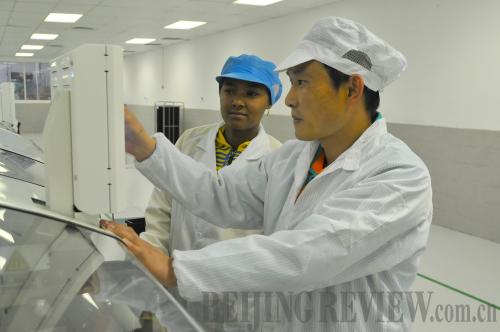 Boris Guo (right), a technical manager gives instruction to a TV assembly line staff member at the Atlantic Hisense factory. [Photo/Francisco Little] 