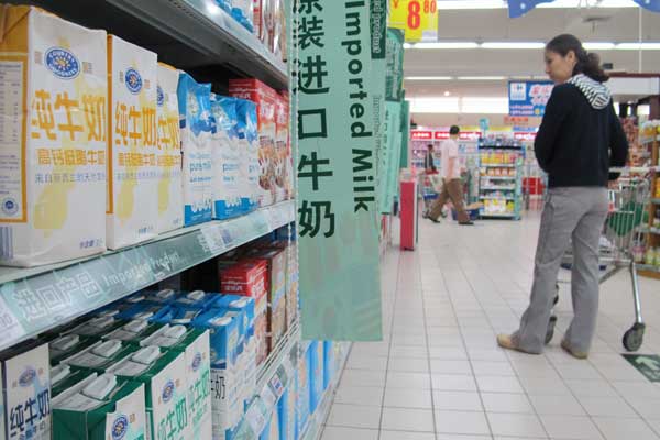 A shopper looking at imported milk at a supermarket in Haikou, Hainan province, in April. China imported 596,200 tons of dairy products in the first four months of this year, up 24.6 percent year-on-year. Shi Yan/For China Daily 