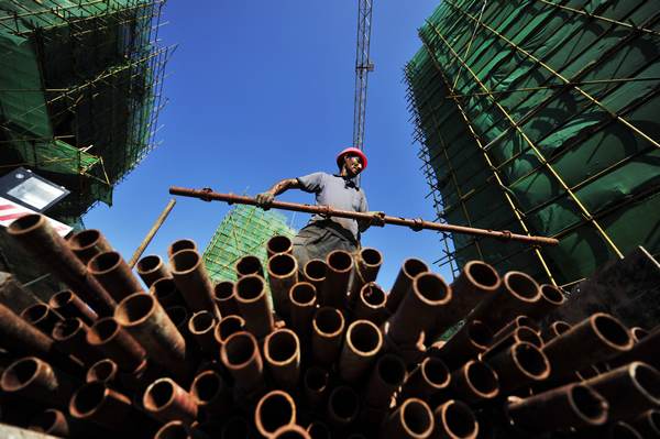 A construction worker carries iron pipes under the searing sun on Thursday in Fuzhou, Fujian province. Laborers who work outdoors without protection are prone to heat stroke. Huang Qipeng for China Daily