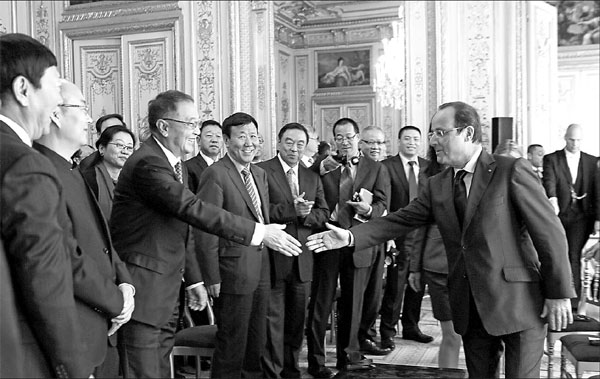 French President Francois Hollande greets Liu Chuanzhi, founder of Chinese PC maker Lenovo Group, who led the visiting delegation of the China Entrepreneur Club at the Elysee Palace. [Photo/Provided to China Daily]
