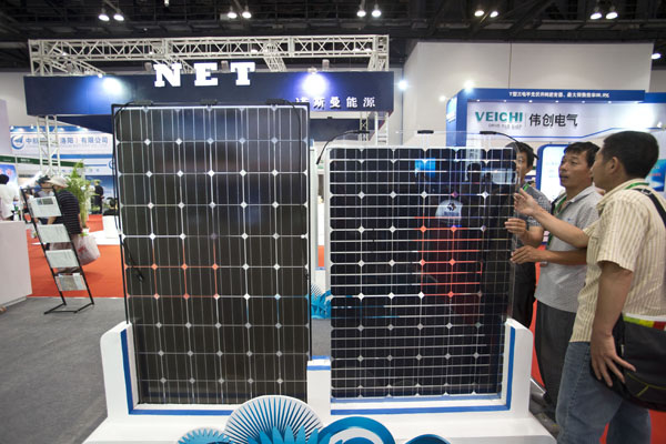 Visitors look at solar panels at the Clean Energy Expo China in Beijing on July 3. Ten of 22 listed solar panel companies have released interim statements indicating a recovery based on expansion in new markets and the domestic market.