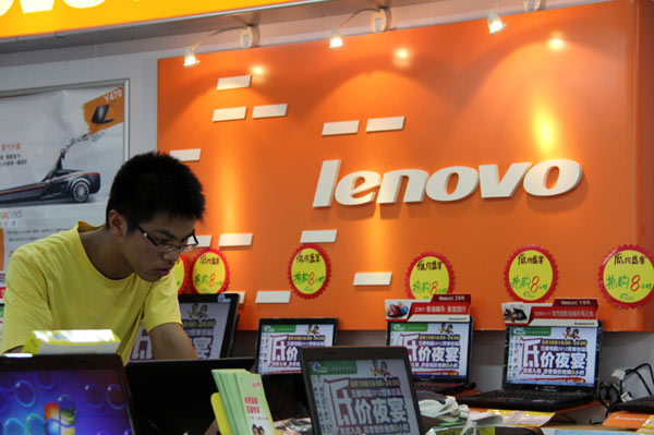 A sales assistant checks a Lenovo laptop at an electronics store in Nantong, Jiangsu province. The Chinese PC maker has shipped at least 12.6 million PCs in the second quarter of the year. Provided to China Daily