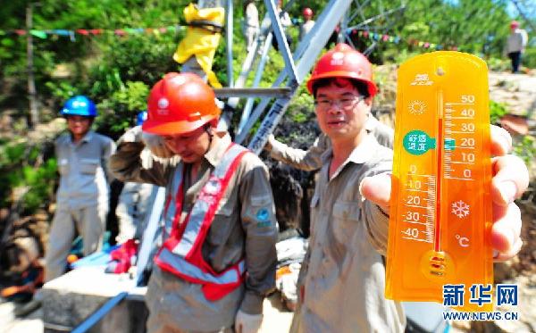 Workers with Transmission and Distribution Engineering Company of Fujian Province make grid maintenance in Xiamen, southeast China's Fujian province, July 4, 2013. The thermometer showed that the temperature was close to 40 degrees Celsius. (Xinhua Photo) 