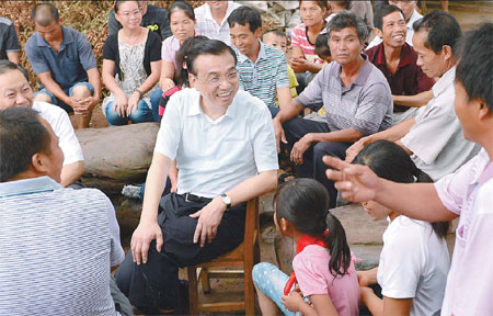 Premier Li Keqiang chats with farmers in Tanliang, a village in Nanning, capital of the Guangxi Zhuang autonomous region, during a recent inspection tour. Ma Zhancheng/Xinhua