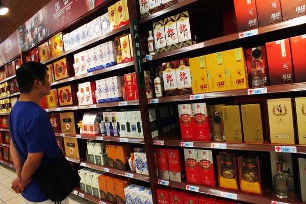 A customer shops for Chinese liquor at a supermarket in Yichang, Hubei province. Sales have plunged since last year, after the central government vowed to crack down on lavish liquor-fueled banquets. Provided to China Daily