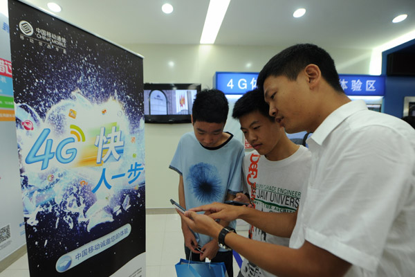 A sales clerk demonstrates the speed of mobile 4G telecom services to customers in Guiyang, Guizhou province. The number of mobile Internet users in the country reached 464 million at the end of June, according to the China Internet Network Information Center.TAO LIANG/XINHUA