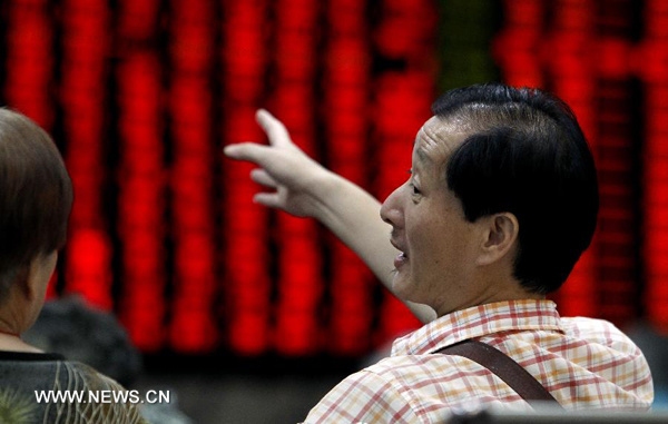 Investors talk about stock information at a trading hall of a securities firm in Shanghai, east China, July 23, 2013. (Xinhua/Ding Ting) 