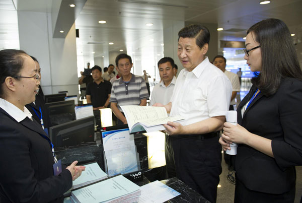 Chinese President Xi Jinping (2nd R), who is also general secretary of the Communist Party of China (CPC) Central Committee, talks with staff members and farmer customers at a rural equity transaction house in Wuhan, capital of Central China's Hubei province, July 22, 2013. Xi made an inspection tour in Hubei from July 21 to July 23. [Photo/Xinhua]