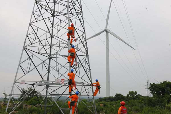 Technical workers conduct maintenance of the power transmission system at a wind-power farm in Chuzhou, Anhui province. The country plans massive investment to boost the proportion of renewable energy in the total energy mixture.PROVIDED TO CHINA DAILY