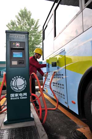 A worker charges an electric bus in Zibo, Shandong province. The city operates 20 of the vehicles. YUAN DELIANG/XINHUA 