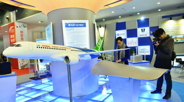 Visitors examine a model of China's first domestically designed commercial aircraft, COMAC's C919, at an exhibition in Beijing. Scientists used 3-D printing technologies to design components for the plane, such as the example pictured below right. Da Wei/for China Daily