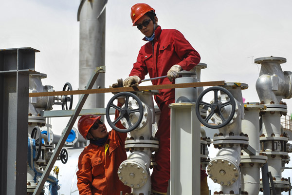 PetroChina workers check gas supply facilities at an oil and gas field in Hotan, in the Xinjiang Uygur autonomous region. The company is reported to be in talks with Lukoil, a Russian oil producer, to jointly develop the West Qurna-2 project in Iraq.WANG FEI/XINHUA
