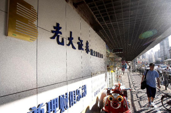 A man walks past a brokerage house of Everbright Securities Co., Ltd., east China's Shanghai, Aug. 16, 2013. The Shanghai Stock Exchange (SSE) said Friday afternoon that the investment strategy department of Everbright Securities Co., Ltd. had encountered a problem in its arbitrage system while operating with its own funds during the morning trade at the bourse, following a dramatic spike in domestic stock indexes. (Xinhua/Ding Ting)