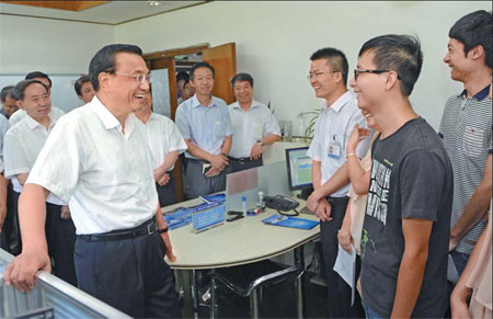 Premier Li Keqiang shares a light moment with students during his visit to Lanzhou University, Gansu province, on Sunday. The premier urges students to remain confident of the job market. Tang Mingming/for China Daily