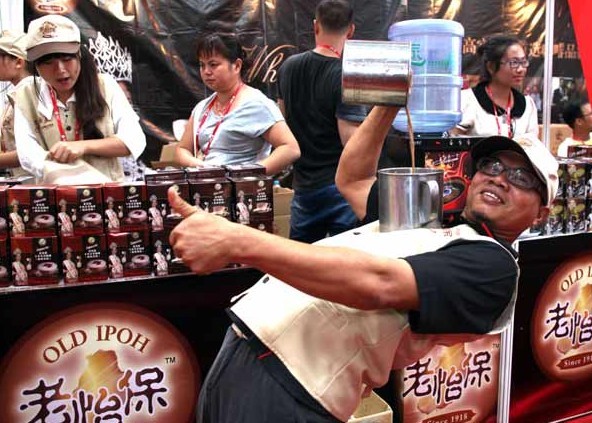 A promoter prepares a traditional drink on Tuesday at the Malaysia booth at the China-ASEAN Expo in Nanning, the Guangxi Zhuang autonomous region. The expo opened on Wednesday. Huo Yan/China Daily