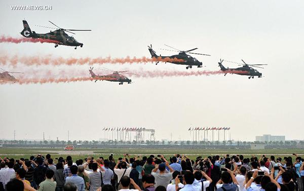 Visitors look at the performance of aerobatic flight at the Second China Helicopter Exposition in Tianjin, north China, Sept. 5, 2013. The exposition was opened on Thursday. (Xinhua/Liu Haifeng)
