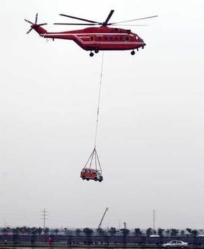 An AC 313 helicopter lifts a vehicle from the scene of a simulated traffic accident during the opening ceremony of the Second China Helicopter Expo in Tianjin on Thursday.Photos by Jia Lei / for China Daily 