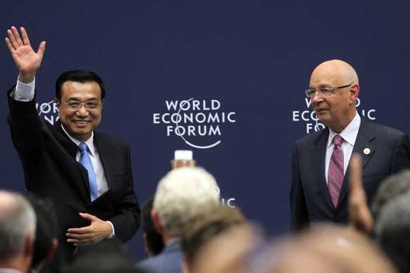 Premier Li Keqiang, accompanied by Klaus Schwab, executive chairman of the World Economic Forum, meets business representatives before the World Economic Forum Annual Meeting of the New Champions, also known as the Summer Davos, in Dalian on Tuesday. The three-day forum is scheduled to start on Wednesday.[ZOU HONG/CHINA DAILY]