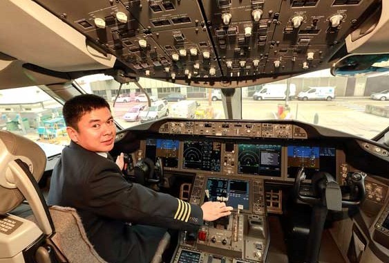 Captain Ji Ye of Boeing 787 looks back from the pilot seat of the Boeing 787, docked at the Heathrow Airport on Sept 10, 2013.[ Xie Songxin/China Daily]
