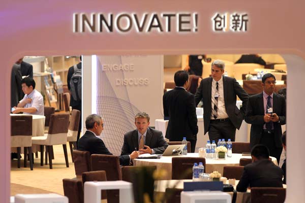 Participants chat during a break at the Summer Davos in Dalian, Liaoning province, on Thursday. Francisco J. Sanchez, US undersecretary of commerce for international trade, said the US is open to Chinese investment. China's direct investment in the US grew 123.5 percent to $4 billion in 2012.[ZOU HONG / CHINA DAILY