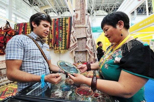 A Chinese customer stops by a Iranian booth at the first China-Arab States Expo convened in Yinchuan, Ningxia Hui Autonomous Region, September 15. [Photo/Xinhua]