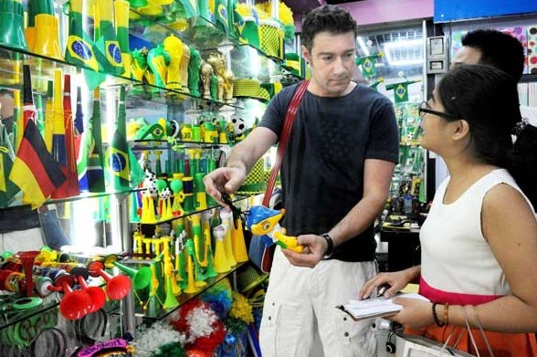 A Brazilian businessman examines sports memorabilia in Yiwu, Zhejiang province, for the 2014 World Cup, to be held in Brazil. PwC says that China will likely experience increasing trade friction from other emerging countries, such as Mexico, Brazil and India. ZHANG JIANCHENG/FOR CHINA DAILY  