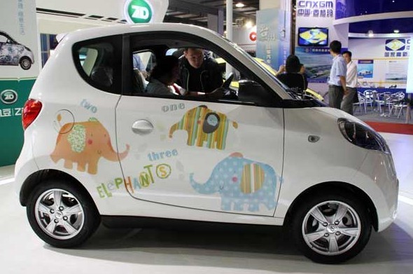Customers examine an electric car at an exhibition in Beijing on Saturday. The government plans to have at least 10,000 new-energy vehicles sold between 2013 and 2015 in each of the country's megacities, according to the guideline for the electric vehicle industry.WU CHANGQING/FOR CHINA DAILY