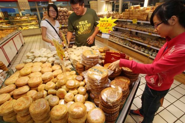Customers choose low-priced mooncakes at a supermarket in Weifang, Shandong province. [Zhang Chi / for China Daily]