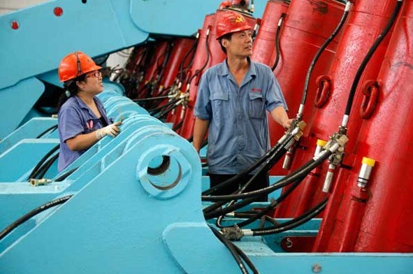 Workers examine mining equipment on Monday in Huaibei, Anhui province. HSBC's preliminary PMI reading for September, which is at 51.2, boosted confidence that the government's annual growth target could be met. XIE ZHENGYI/FOR CHINA DAILY