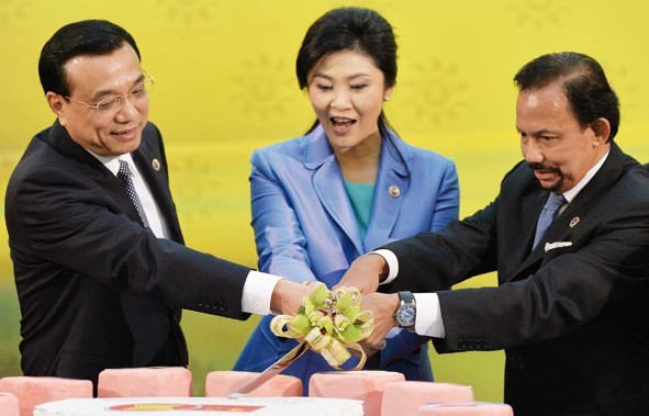 From left: Premier Li Keqiang, Thai Prime Minister Yingluck Shinawatra and Bruneis Sultan Hassanal Bolkiah cut a cake to celebrate the 10th anniversary of the strategic partnership between China and ASEAN in Bandar Seri Begawan, Brunei, on Wednesday. Philippe Lopez/Agence France-Presse