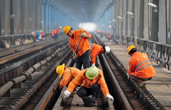 Workers conduct railway maintenance work on a Yangtze bridge in Jiujiang, Jiangxi province. The World Bank cut its 2013 China GDP growth forecast on Monday to 7.5 percent from 8.3 percent in April. Hu Guolin/For China Daily