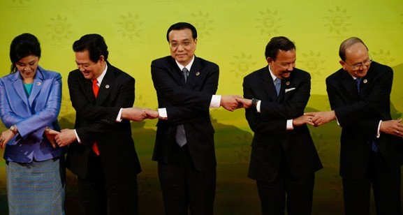 Chinese Premier Li Keqiang (second from right) links his hands with ASEAN leaders Thai Prime Minister Yingluck Shinawatra (left), Vietnamese Prime Minister Nguyen Tan Dung (second from left) and Brunei Sultan Hassanal Bolkiah (right) for a group photo before the 16th China-ASEAN Summit in Bandar Seri Begawan, Brunei, on Wednesday. Vincent Thian/Associated Presse