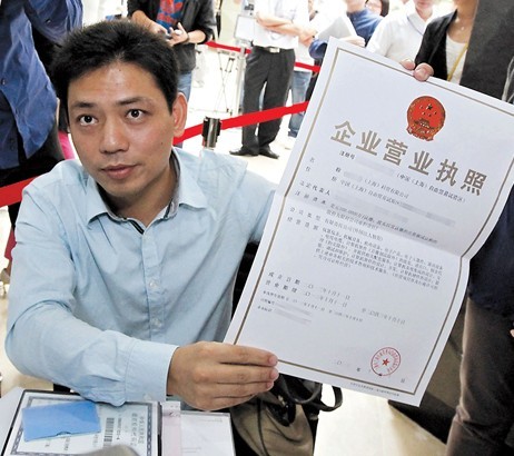 A corporate representative receives the business license for his company, one of the first that have applied to register in the pilot free trade zone in Shanghai, yesterday. Xinhua