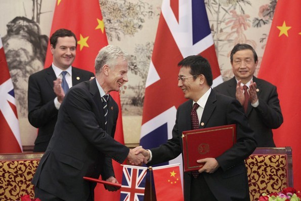 Vice-Premier Ma Kai (right) and UK Chancellor of the Exchequer George Osborne oversee the signing of an agreement between the two countries in Beijing on Tuesday. The UK is the most popular destination in Europe for Chinese investment. Zou Hong / China Daily  