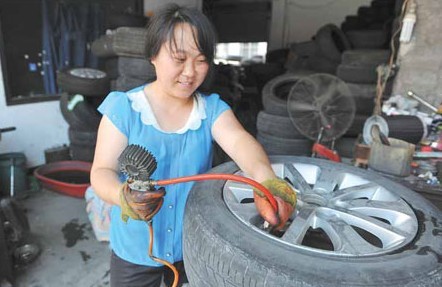 A technician services a tire in Lin'an, Zhejiang province. Top tire makers including Continental and Michelin are scrambling to meet surging demand in the world's largest auto market. Hu Jianhuan / for China Daily